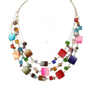 A multi-strand beaded necklace set displayed on a white mannequin bust, including a statement necklace and matching drop earrings. The jewelry features a variety of colorful square and round beads in red, pink, blue, green, orange, brown, purple, and clear glass, suspended on silver-tone wires.