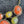 Load image into Gallery viewer, A close-up of a statement necklace with irregular orange and yellow-green cabochon stones in ornate silver-tone settings, shown on a dark textured surface with matching drop earrings partially visible at the top left.

