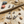 Load image into Gallery viewer, Silver star and smiley face earrings on a sandy surface with shells and stones.
