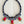 Load image into Gallery viewer, Colorful beaded necklace with red pendants on a dark surface
