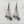 Load image into Gallery viewer, Pair of earrings with pearls and brown strings on a light wooden surface
