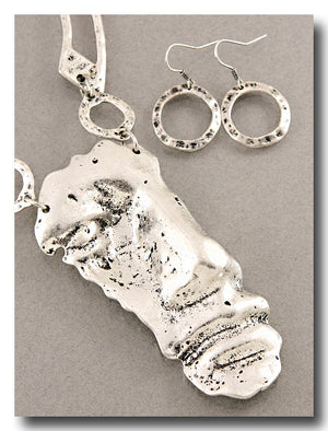 A sterling silver jewelry set featuring a textured abstract pendant necklace and matching textured circular hoop earrings, displayed on a neutral gray background.
