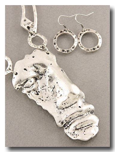 A sterling silver jewelry set featuring a textured abstract pendant necklace and matching textured circular hoop earrings, displayed on a neutral gray background.