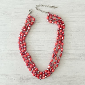 Red beaded necklace on a beige background