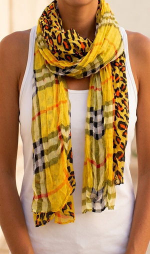 Yellow scarf with leopard print and checkered pattern draped around a person's neck.