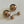 Load image into Gallery viewer, Set of gold spherical earrings on a light gray background
