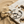 Load image into Gallery viewer, Gold and silver hoop earrings on a marble surface with sand and shells in the background

