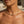 Load image into Gallery viewer, A close-up lifestyle shot of a model wearing a delicate gold snake chain necklace with a small central clasp, set against a softly blurred background.
