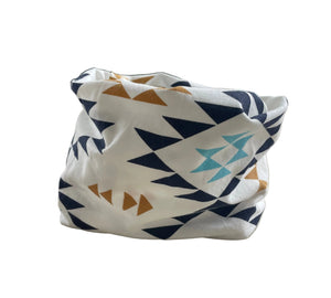 Patterned pouch attached to a chair armrest with a window and plant in the background