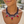 Load image into Gallery viewer, Close-up of a person wearing a colorful beaded necklace with red stones.
