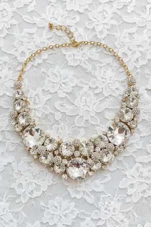 Gold necklace with large crystal beads on a dark surface