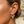 Load image into Gallery viewer, Close-up of an ear wearing a set of diamond earrings with a blurred natural background.
