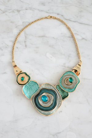 Decorative necklace with circular design and turquoise stones on a dark surface