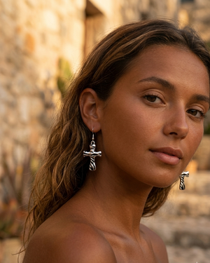 Woman wearing silver earrings with a blurred outdoor background