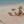 Load image into Gallery viewer, Two children playing on a beach with a pink blanket and toys.
