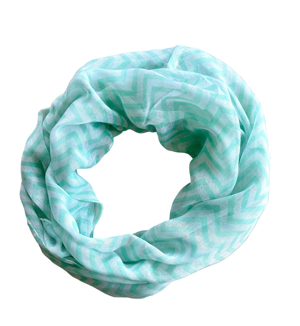 Light blue patterned infinity scarf on a beige surface