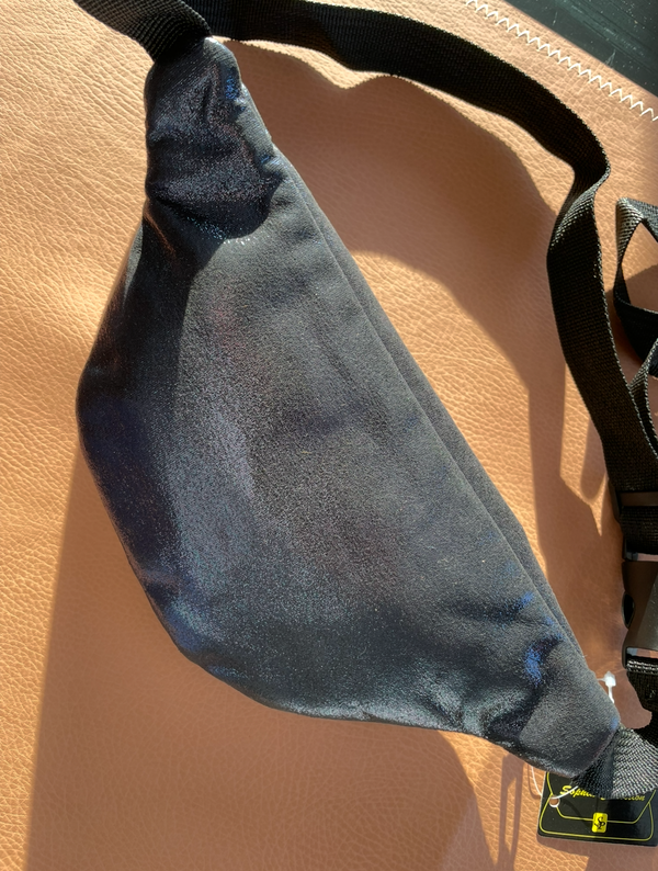 Black bag with a strap on a beige surface