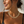 Load image into Gallery viewer, A close-up lifestyle shot of a woman wearing a chunky gold chain necklace with interlocking oval links, paired with a black ribbed tank top against a textured white wall.
