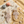 Load image into Gallery viewer, Pair of sparkling earrings on a marble surface with sand and shells around
