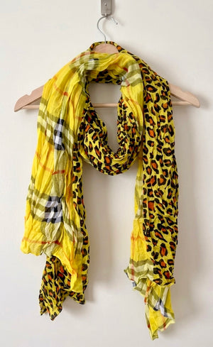 Yellow scarf with leopard print pattern draped over a wooden hanger on a white background