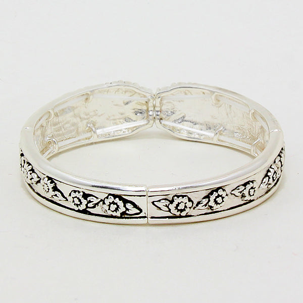 Silver bangle with floral patterns on a white background