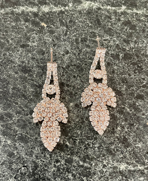 Pair of diamond earrings on a dark marble surface