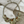 Load image into Gallery viewer, Necklace with sunburst designs and amber-colored stones on a marble surface

