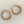 Load image into Gallery viewer, Gold hoop earrings with clear gemstones on a dark textured surface
