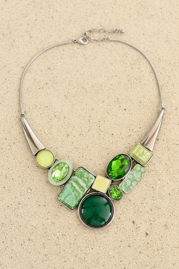 Necklace with green and silver design on a dark surface