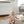 Load image into Gallery viewer, Baby sitting on a mat in a room with a white wall and furniture.
