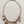 Load image into Gallery viewer, A copper-toned statement necklace with multiple dangling charms, including heart-shaped pendants, a leaf charm, flower charms, and faux pearl beads, displayed on a light wood background.
