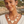 Load image into Gallery viewer, A woman wearing a cream-colored geometric statement necklace and matching drop earrings, photographed outdoors against a blurred coastal background.

