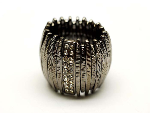 Silver ring with textured design and embedded stones on a white background