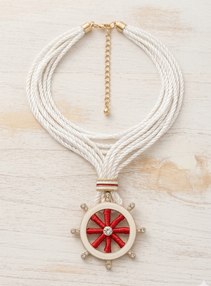 Necklace with a red and white wheel pendant on a light wooden surface