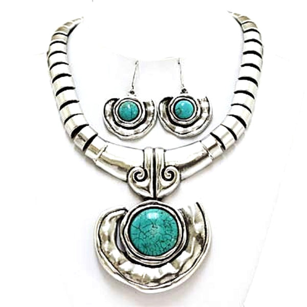 A silver-toned jewelry set featuring a necklace and matching earrings with oval turquoise stones, displayed on a white background.