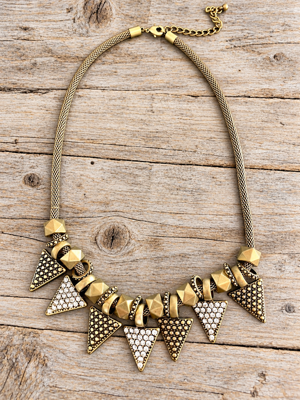 Golden Edge Statement Necklace – Crystal Triangle Bib Necklace lay flat on a wood