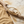 Load image into Gallery viewer, Gold bracelet on a branch with sand and stone in the background
