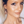 Load image into Gallery viewer, Woman with a ponytail wearing earrings and a white top against a plain background
