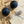 Load image into Gallery viewer, Black spherical earrings with silver studs on a sandy surface
