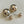 Load image into Gallery viewer, Pair of gold spherical earrings on a light gray background

