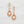 Load image into Gallery viewer, Rose gold earrings with orange teardrop-shaped gemstones on a white background
