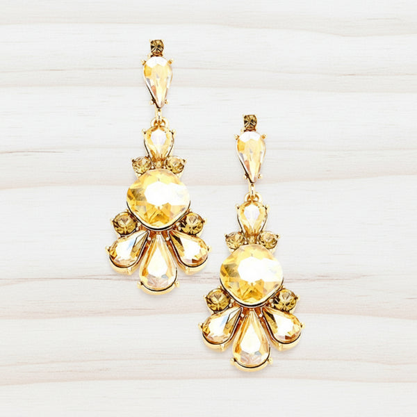 Gold earrings with yellow gemstones on a white background