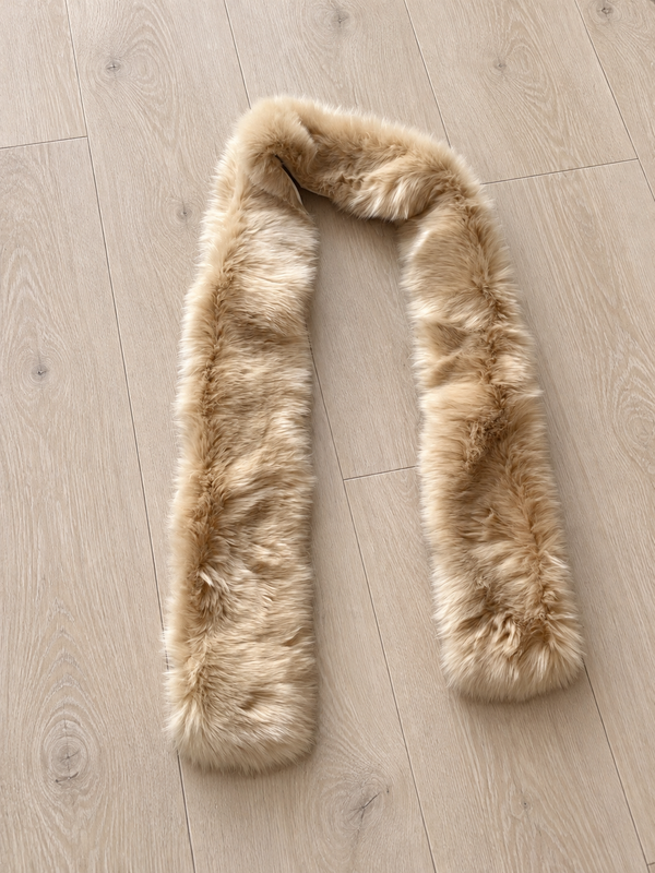 Full beige faux fur scarf laid flat on wood