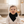 Load image into Gallery viewer, Baby sitting on a cushion in a nursery wearing a white onesie with a black bib.

