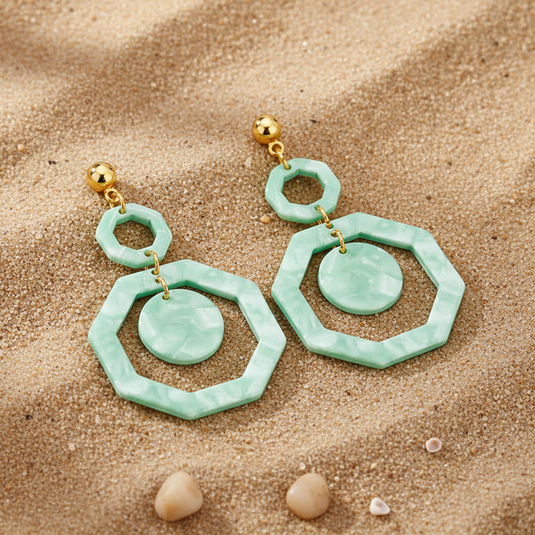 Pair of green marbled earrings with gold accents on a white background