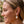 Load image into Gallery viewer, Close-up of a woman wearing a gold earring with a blurred natural background
