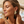 Load image into Gallery viewer, Woman wearing gold earrings with black tassels on a beach setting
