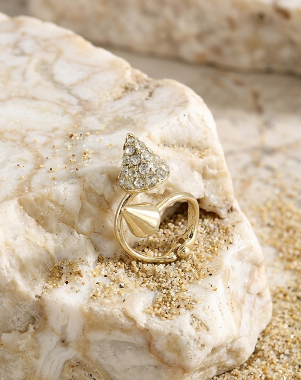 Gold ring with a diamond on a textured stone surface