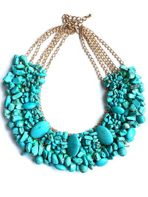 Turquoise stone necklace with gold chain on a white background