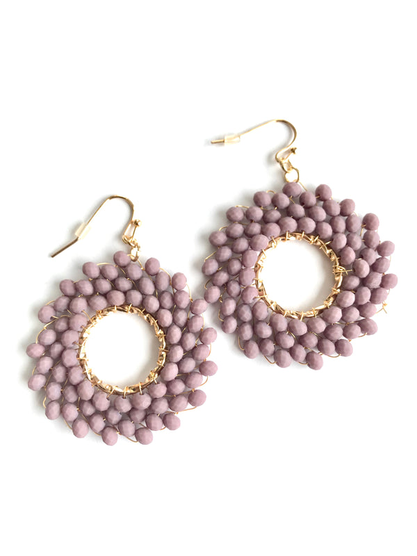 Pair of pink beaded earrings with gold loops on a white background